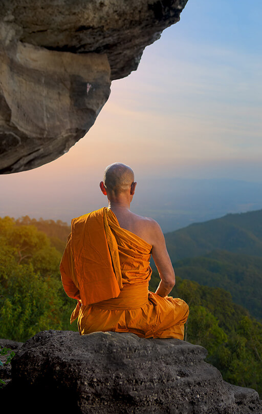 Buddhist monk sitting on top of a mountain